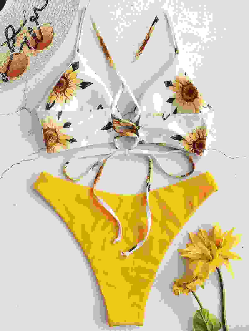 Sunflower print padded bikini top paired with yellow high-cut bikini bottom. Stylish women's bandage bathing suit for summer beachwear.