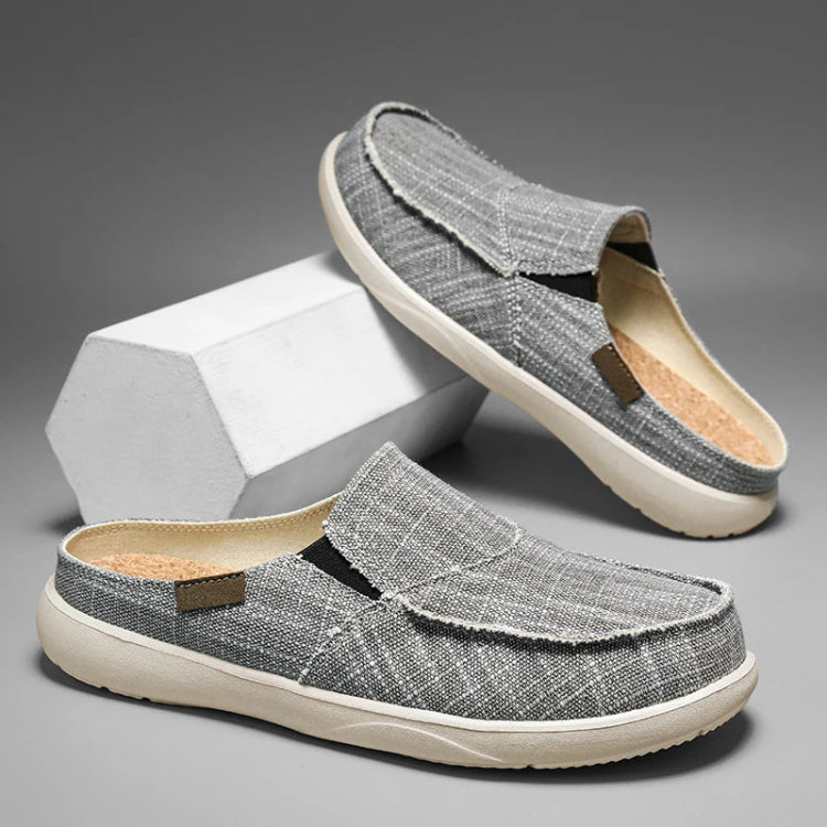 Gray slip-on shoes with white soles on a gray background